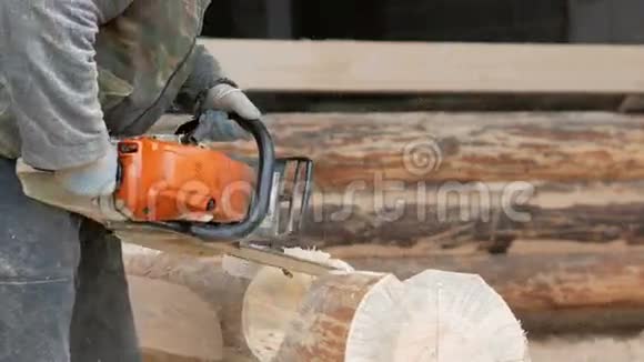 建筑工人为未来的家砍柴电锯建筑工人头上戴防护面罩和耳机视频的预览图