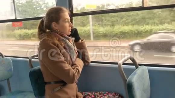 一个美丽的女孩带着悲伤的眼睛坐在电车里视频的预览图