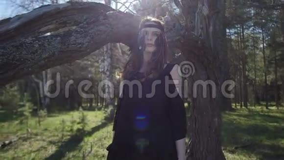 穿着黑色裙子的漂亮女孩在树林里散步视频的预览图