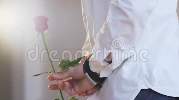 一个手捧红玫瑰的男人特写拍摄红色史诗视频的预览图