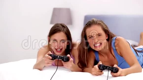 女孩们在床上玩电子游戏视频的预览图
