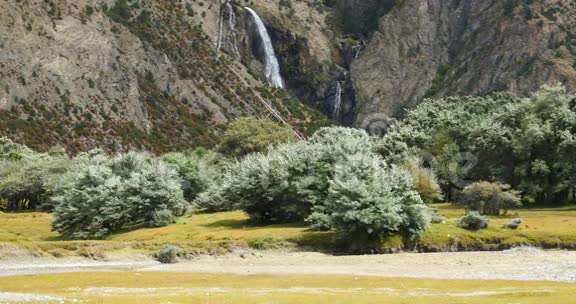 瀑布流淌在山谷中灌木丛在西藏山区的食物上视频的预览图