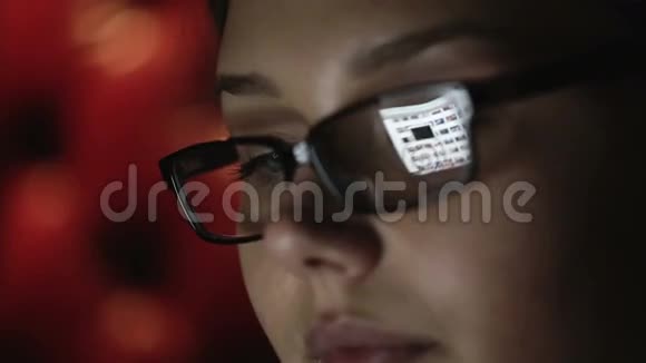 一个戴眼镜的年轻女人晚上工作的肖像特写侧脸视频的预览图