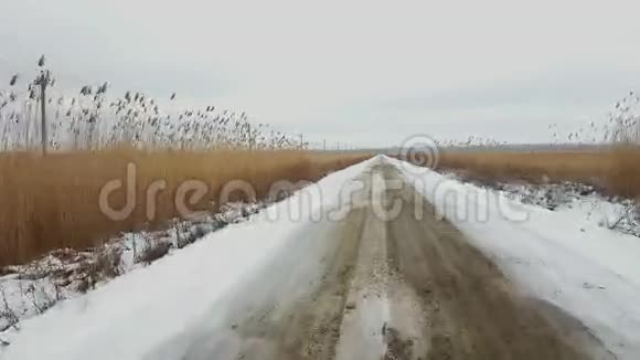 在雪地上驾驶着孤独的乡村道路视频的预览图