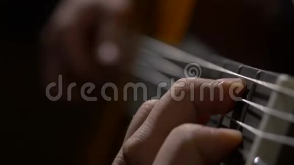 关闭吉他手弹声吉他一个手指放在吉他上的男人近距离射击视频的预览图