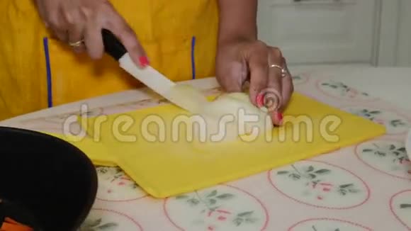 女人在切割板上切洋葱然后倒在上面视频的预览图