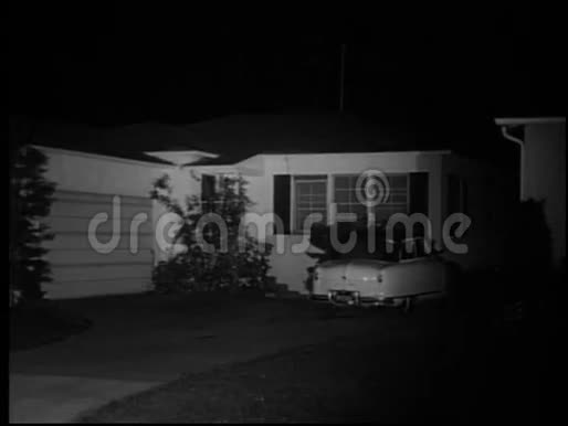 20世纪50年代汽车在夜间驶出郊区车道视频的预览图