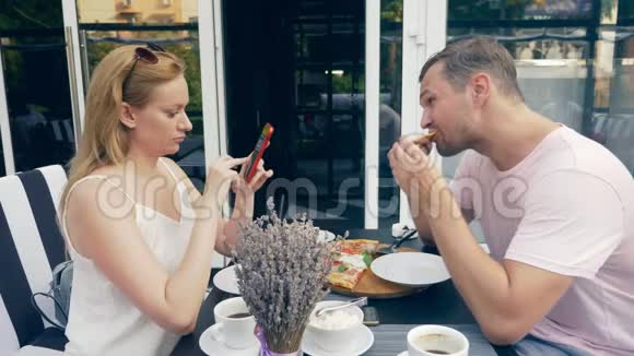 一对在户外咖啡馆男女约会一个搭档看着他的手机第二个试图和他说话4k视频的预览图