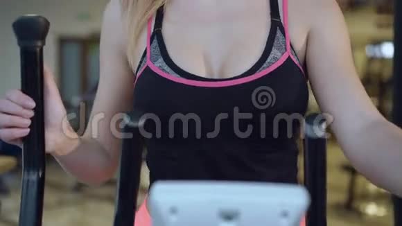 有魅力的女孩在健身房用自行车模拟器锻炼视频的预览图