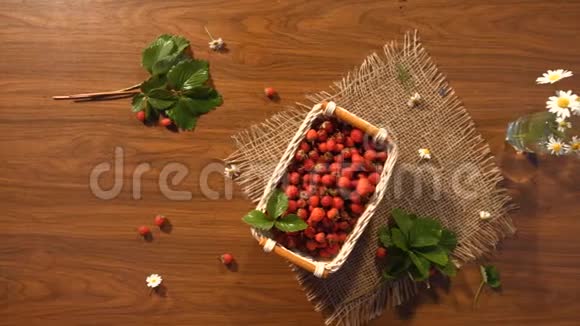 草莓和一束洋甘菊放在桌子上上景视频的预览图