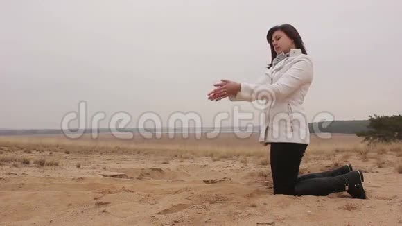 女孩站在沙滩上跪着视频的预览图