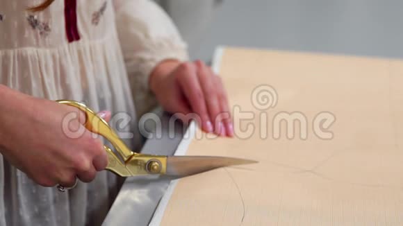 年轻的女设计师脖子上挂着胶带线站在制衣工作室用粉笔和规则画线条视频的预览图