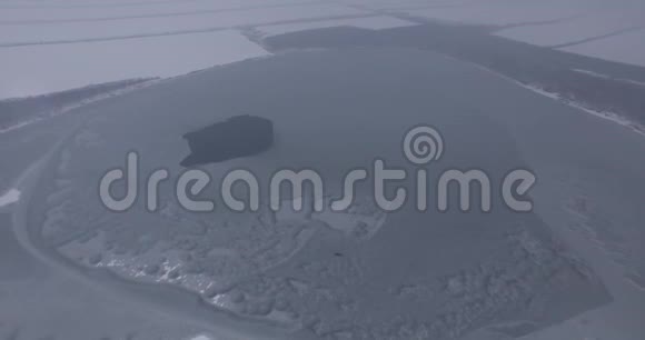 雾中的一个大湖照相机飞过一个结冰的湖视频的预览图
