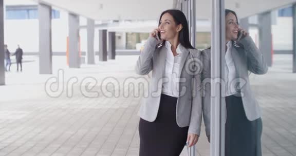 在办公室外面打电话给一个微笑的美女视频的预览图