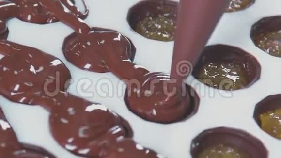 特写厨师用手挤压融化的巧克力视频的预览图