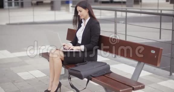 坐在长凳上拿着笔记本的女人视频的预览图