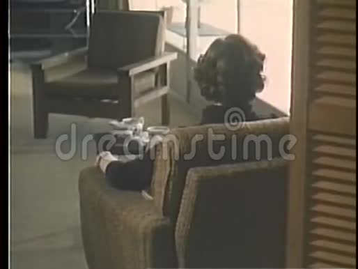 坐在扶手椅上沉思的女人的后视图视频的预览图