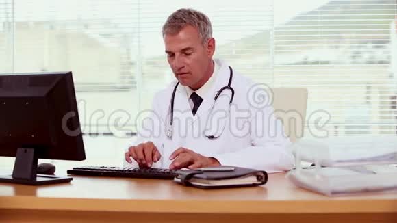 微笑的医生用他的电脑视频的预览图