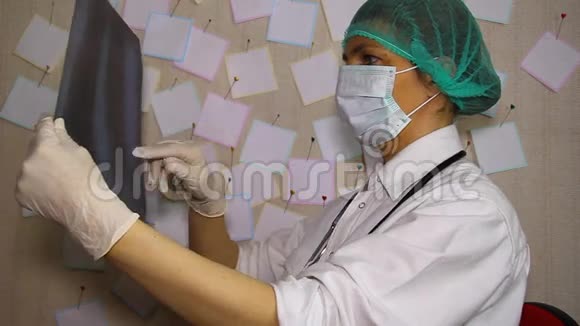 戴口罩的年轻医生检查胸部X线片视频的预览图