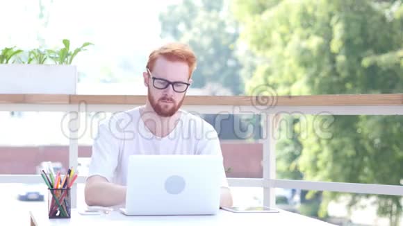 在笔记本电脑上工作坐在办公室阳台上室外视频的预览图