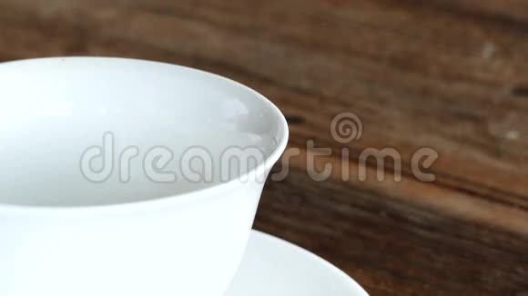 茶壶把热气腾腾的茶倒入茶杯里视频的预览图
