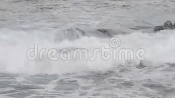 波浪在淹没的岩石上飞溅视频的预览图