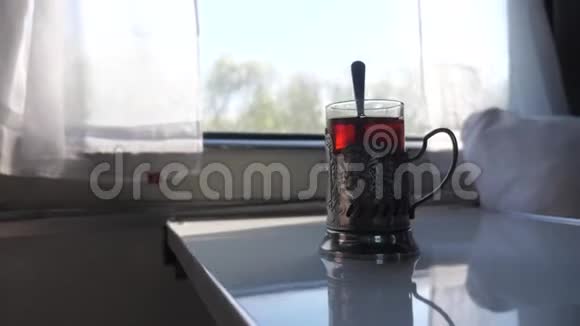 铁路旅行概念一杯玻璃杯中装有勺子的茶一个老式的站在火车车厢的桌子上视频的预览图