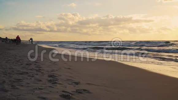 在海浪和沙滩上的云层后面日落视频的预览图