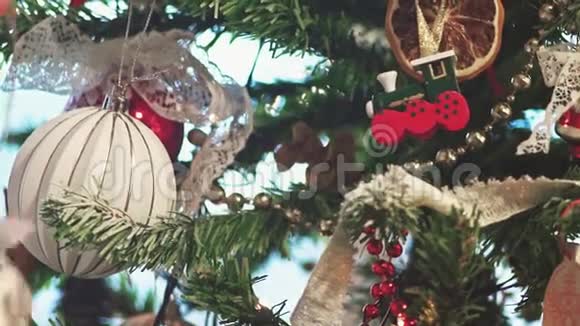圣诞树上的新房子抵押贷款年轻女子正在把玩具放在圣诞树上慢动作视频的预览图