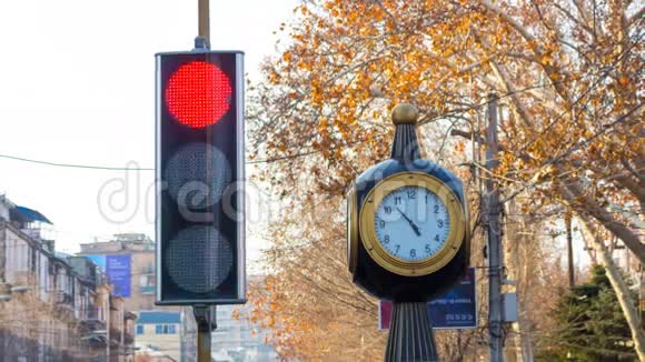 时间流逝在城市背景上有一个时钟的红绿灯与树木视频的预览图