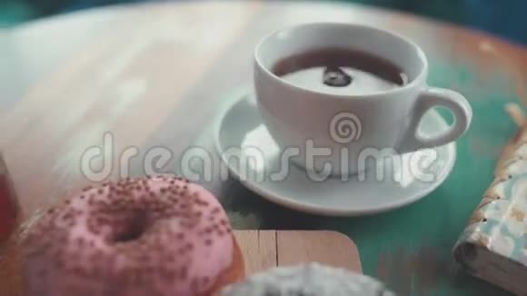 特写红茶和甜甜圈桌上的早晨作文视频的预览图