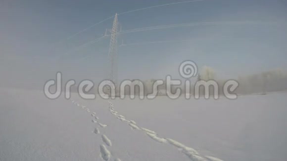 雪堆期间带电塔架和红色宅基地的景观时间间隔4K视频的预览图