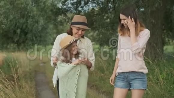 家庭母亲和孩子两个女儿一起沿着乡间小路散步视频的预览图