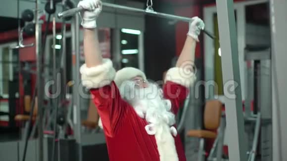 圣诞老人圣诞节在健身房训练练习机视频的预览图