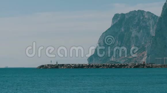 地中海在美丽的海浪中在白沙和直布罗陀岩石的背景下拍打着视频的预览图