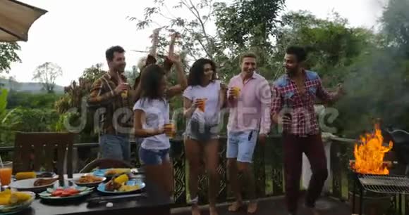 年轻人一边做饭一边跳舞快乐的团体在夏天的露台上聚会视频的预览图