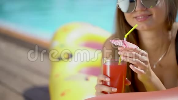 夏天美丽的年轻女子比基尼女孩在热带游泳池放松喝新鲜鸡尾酒的女人视频的预览图