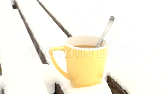双手在冬天的公园里用热水瓶在黄色的杯子里准备热饮料木制长凳上的新鲜粉末雪视频的预览图