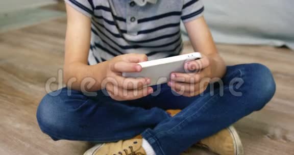 一个男孩在智能手机上玩游戏视频的预览图