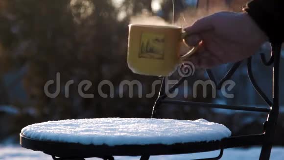 一杯雪盖椅子上放着热茶视频的预览图