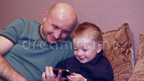 小男孩和他叔叔在电话里看电影视频的预览图
