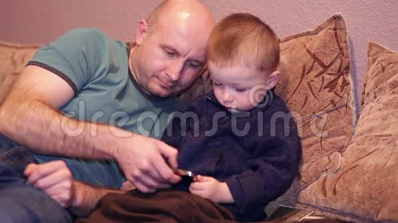 小男孩和他叔叔在电话里看电影视频的预览图