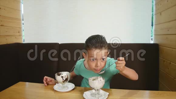 快乐的小女孩和男孩在咖啡馆吃冰淇淋视频的预览图