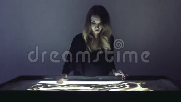 女人在黑暗的房间里用沙子和沙子做动画视频的预览图