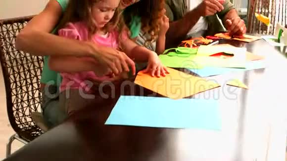 家长和孩子们一起在桌子上做纸形视频的预览图