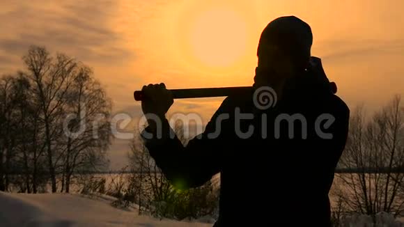 日落时分Lumberjack和他的斧子站在一起视频的预览图