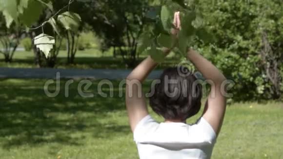 在绿色公园做瑜伽的女孩视频的预览图