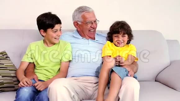 老人和他的孙子坐在沙发上视频的预览图