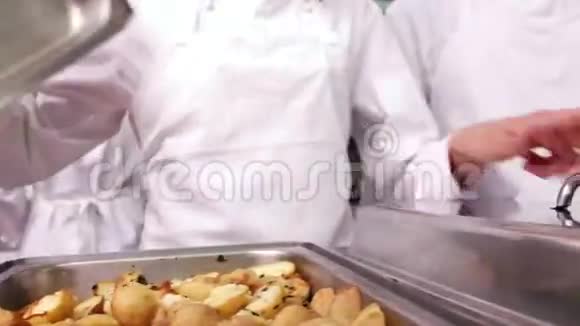 一排厨师从盛菜盘上取下盖子视频的预览图