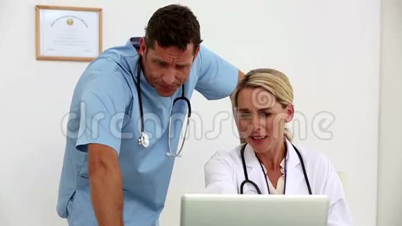 两个医生一起在办公室里用笔记本电脑视频的预览图